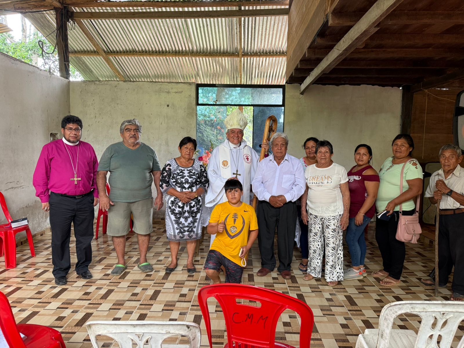 People standing in a row in front of chairs at the Mission church in the Amazon rainforest