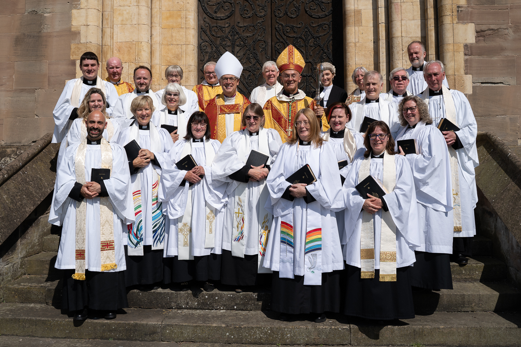 Newly ordained priests standing outside the cathedral with the bishops