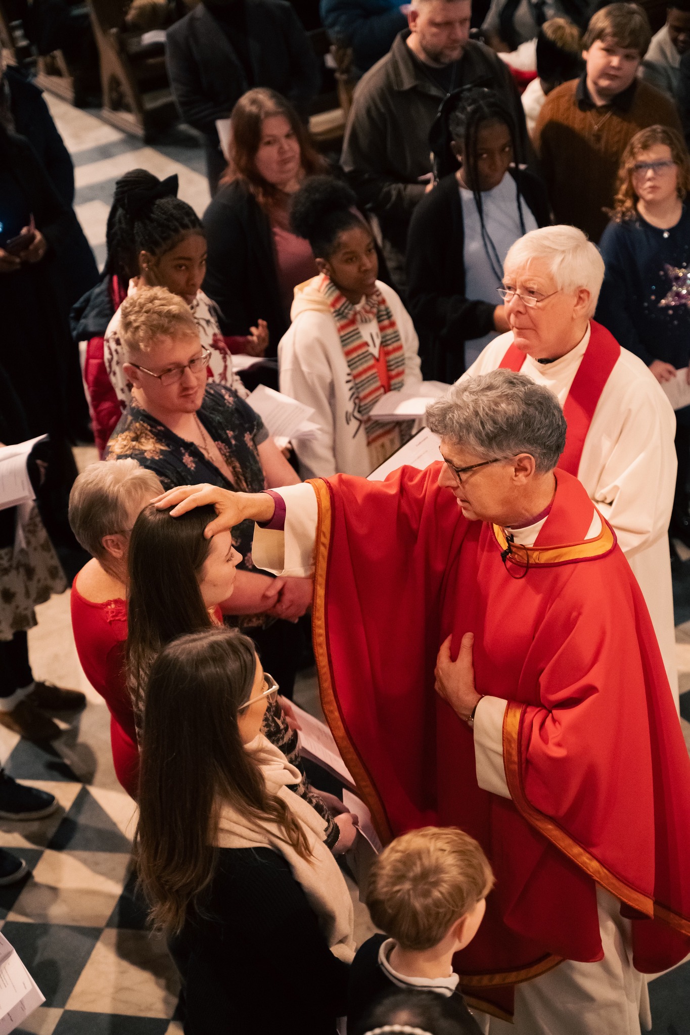 Bishop Martin confirms a candidate while others look on