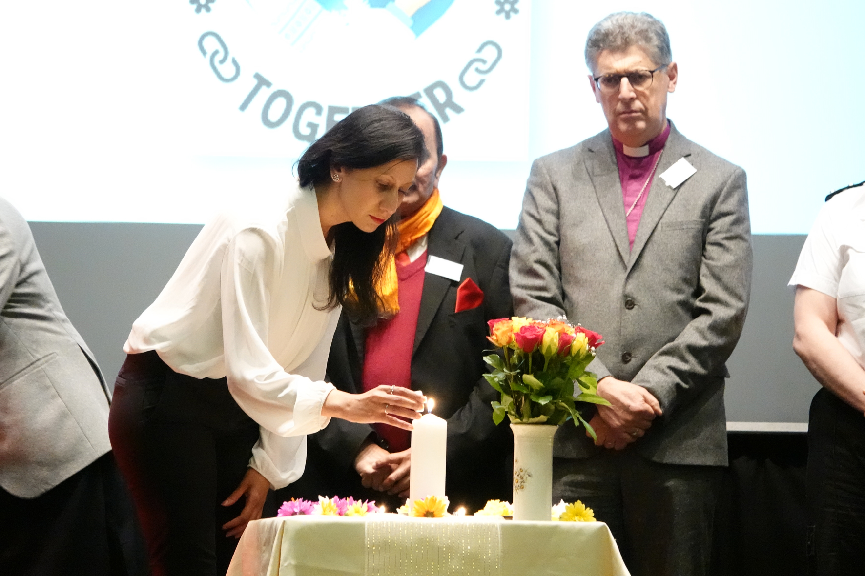 MP for Dudley, Sonia Kumar lights a candle as Bishop Martin & others look on