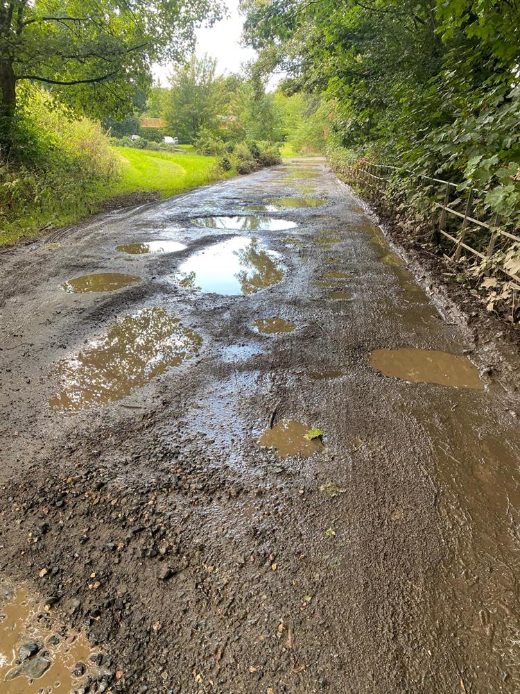 Puddles on the driveway to great Witley church