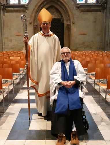 Tony Bill sitting in a wheelchair next to Bishop Martin
