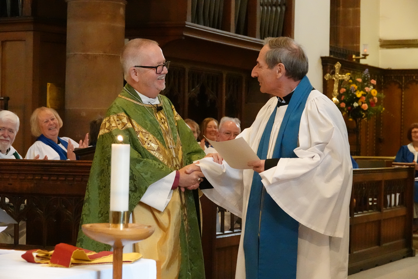 Reader Ron Rust receives a long service certificate from Bishop Alan