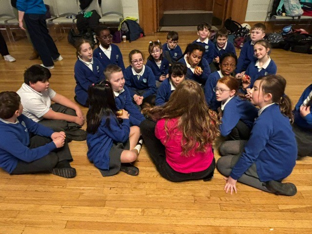  A group of children sitting on the floor as Kirsty from iSingPop talks to them