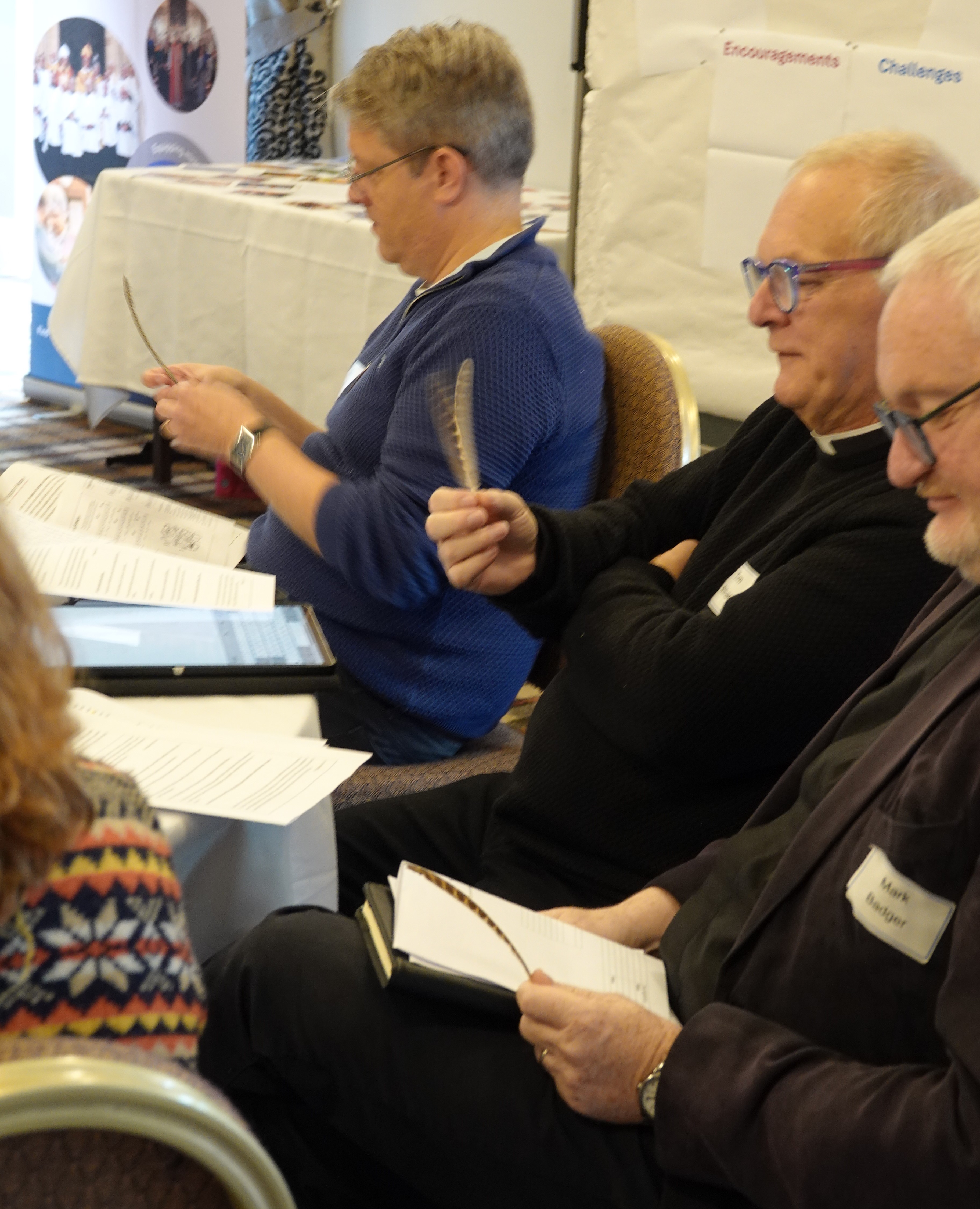 Delegates examine the feathers they have been given