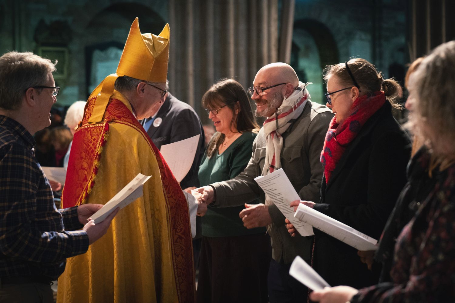 Bishop Martin handing a certificate to an ALM as other ALMs look on.