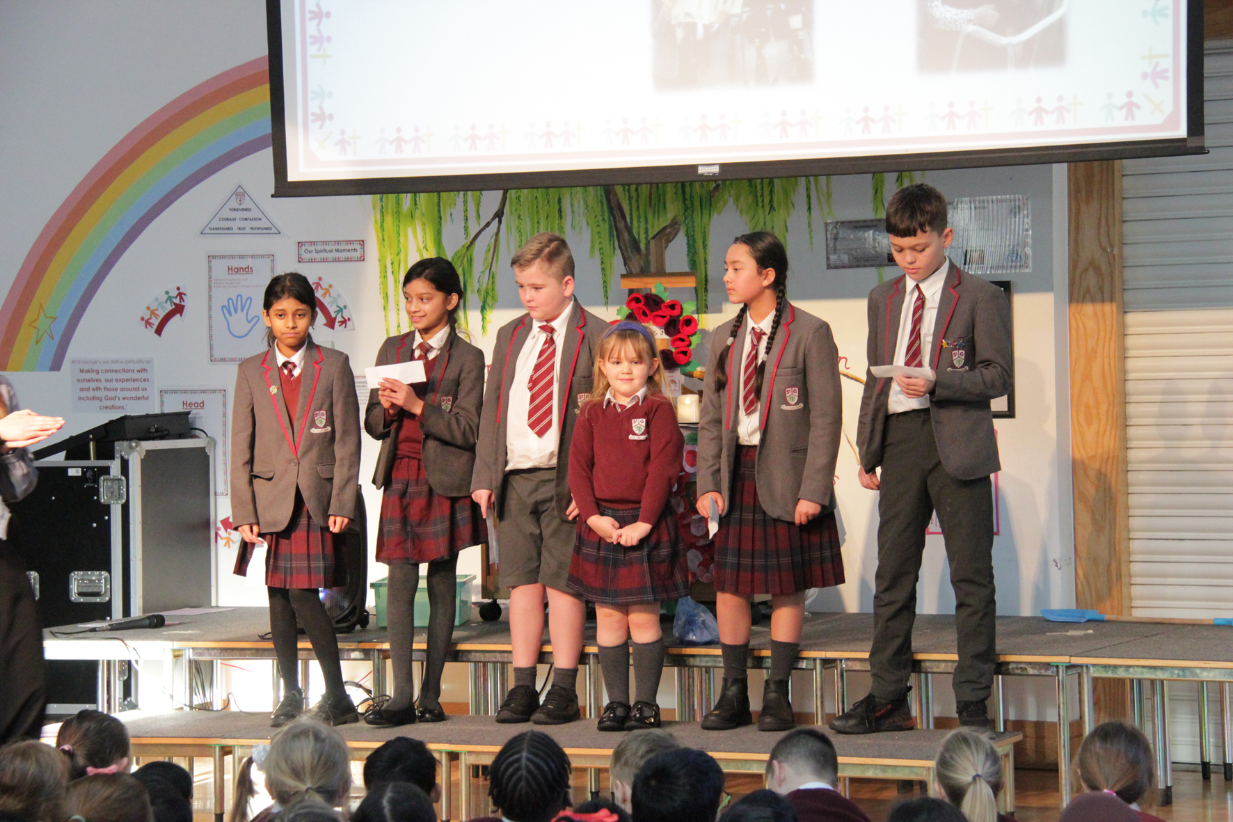 Six pupils from St George CE Primary stand on a stage to read out things they've enjoyed