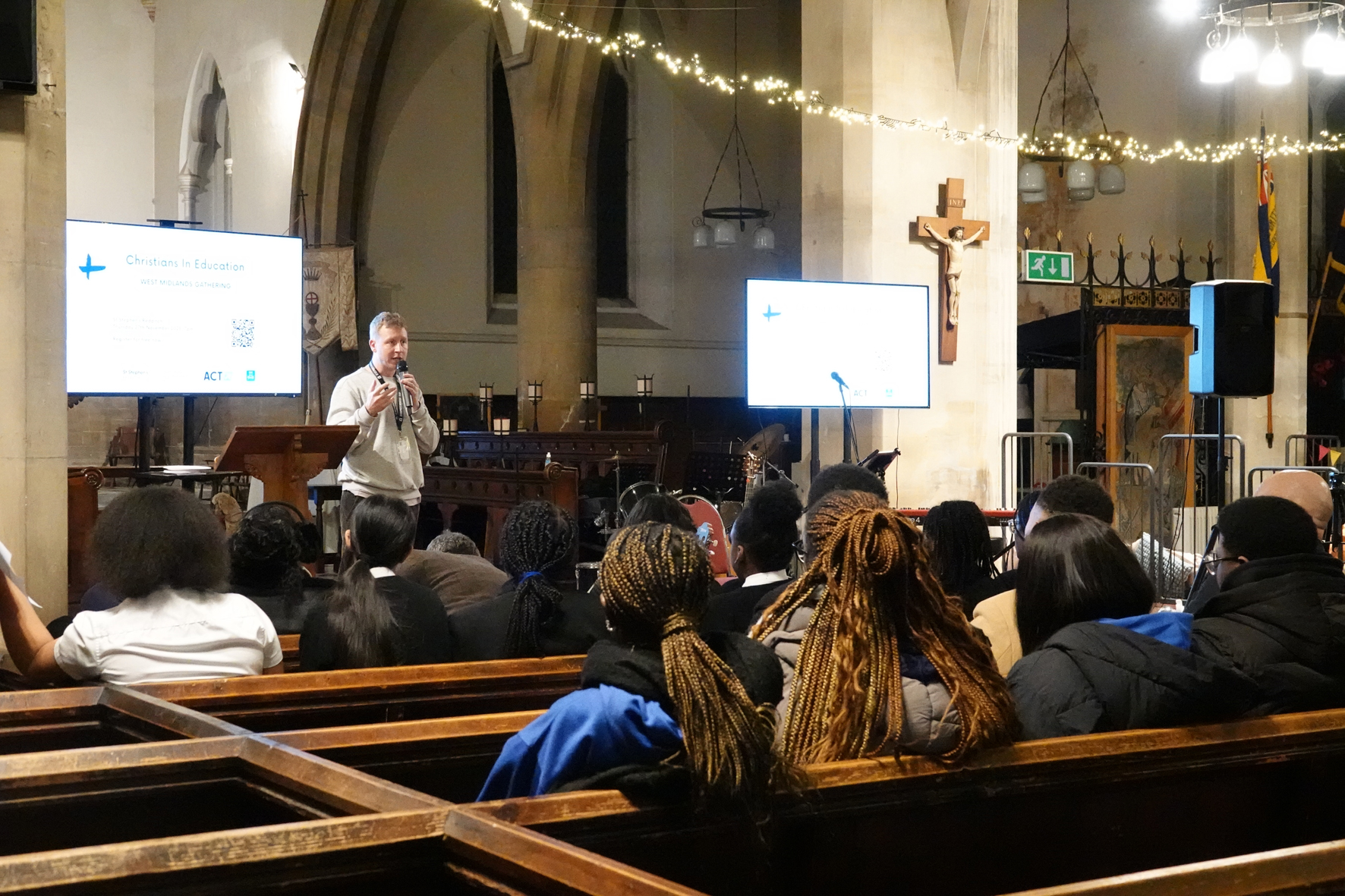 Fraser standing at the front of St Stephens with people sat in pews listening to him.
