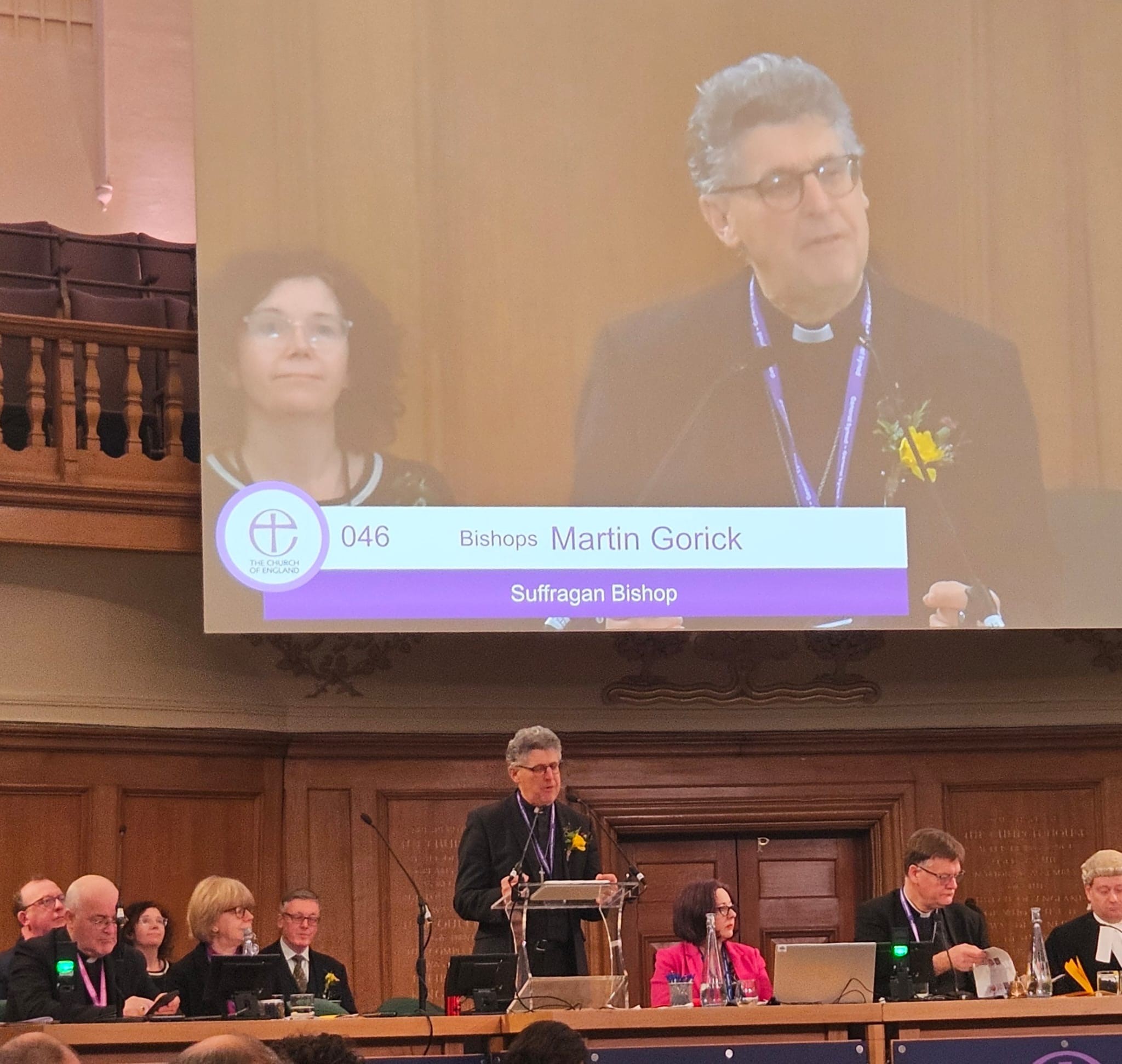 Bishop Martin presenting the General synod motion with his image on the big screen behind him.