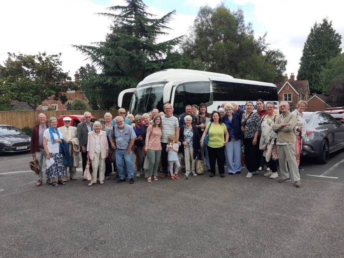 Members of Malvern Priory and the EKM in front of a coach