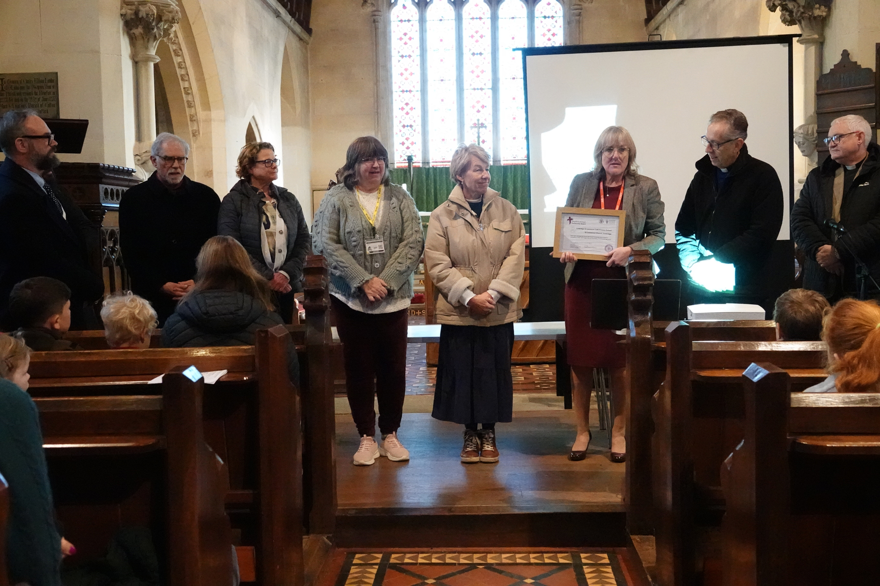 A group of people stood at the front of Lindridge Church holding an award certificate