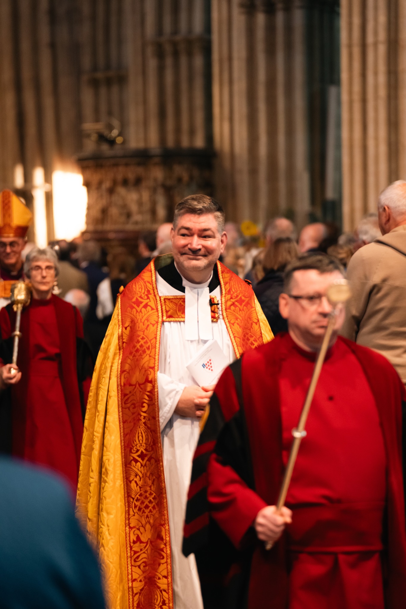 Stephen Edwards walking behind the verger through the Cathedral