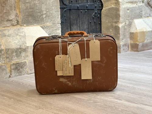 A brown suitcase with luggage labels attached to it
