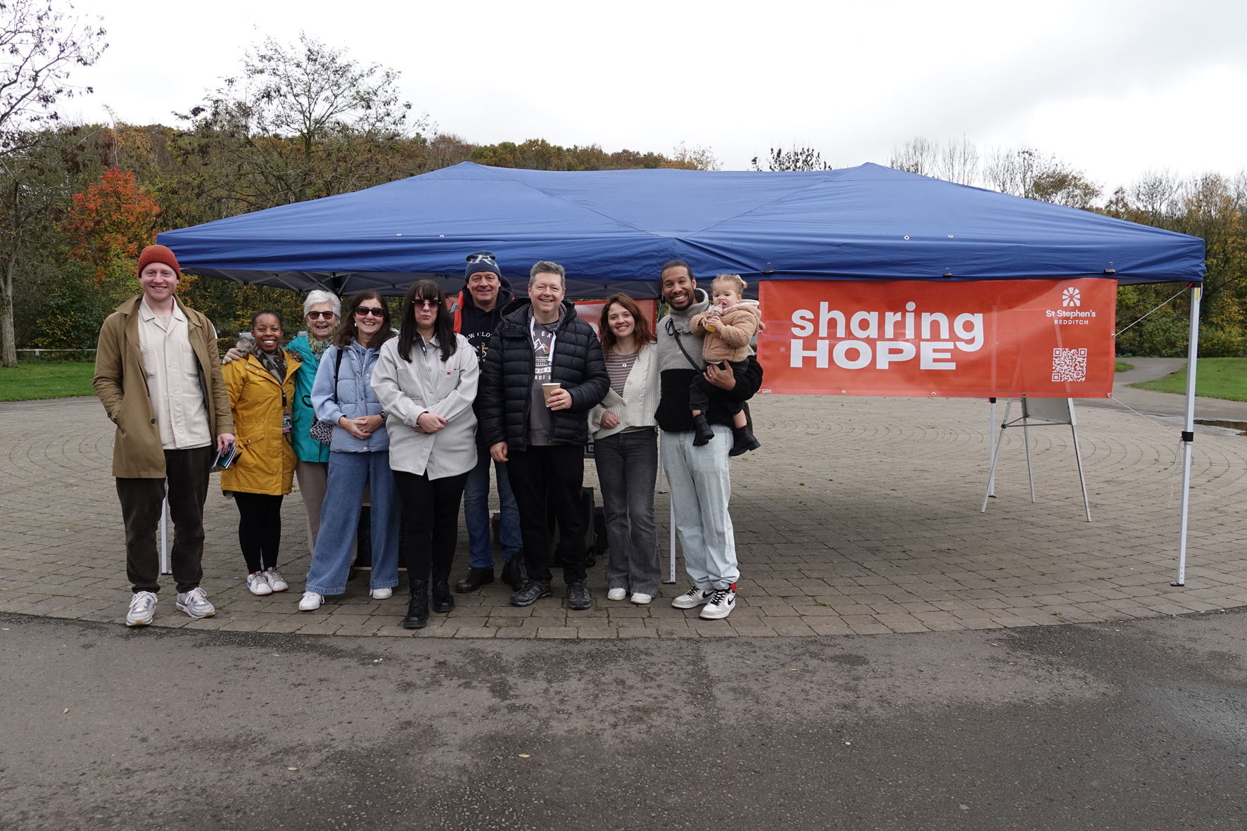 Members of St Stephen's, Redditch standing in front of a gazebo with a sharing hope banner