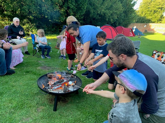 People toasting marshmallows over a fire pit