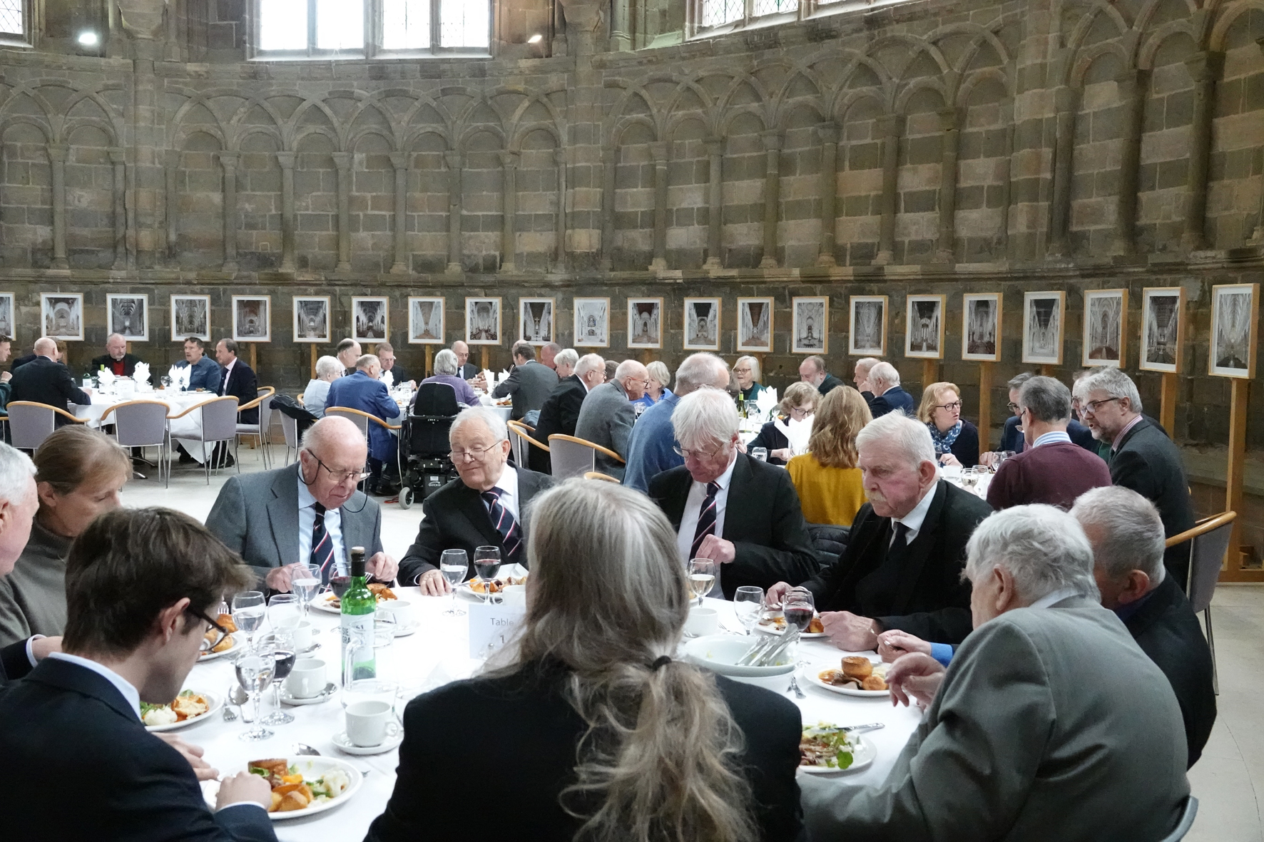 Past members of the voluntary choir sitting down to lunch around round tables