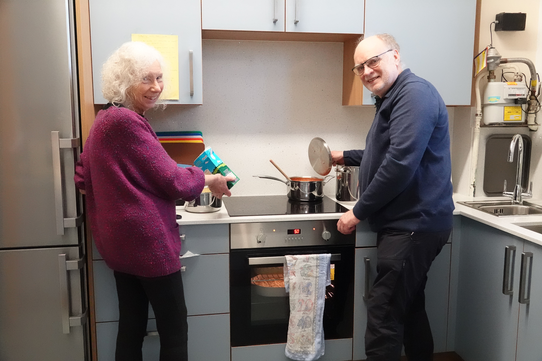 Two volunteers cooking at the Malvern Link after school club