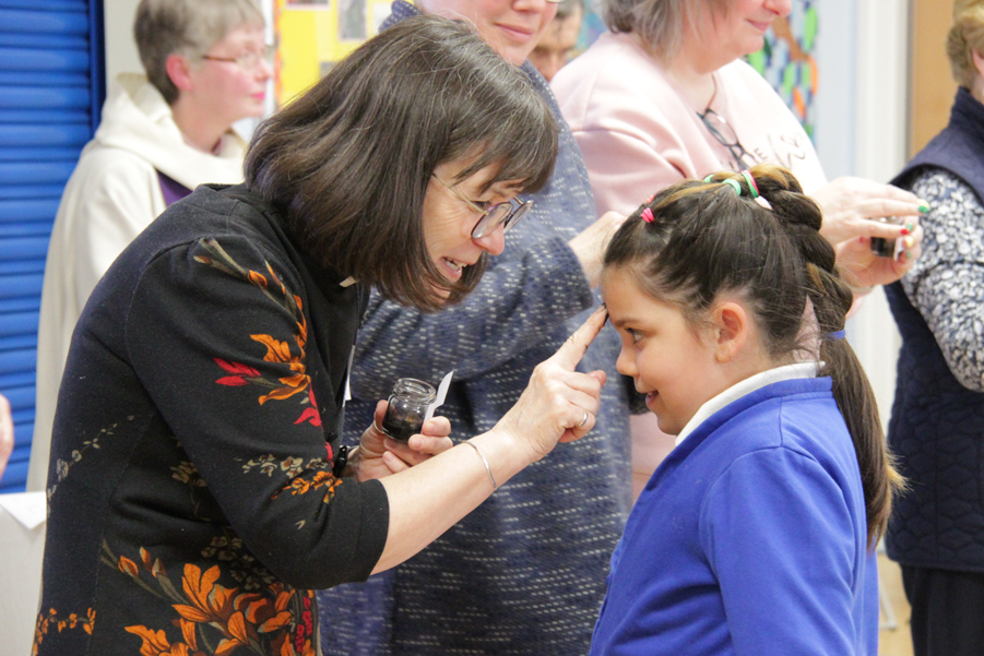 Young girl receiving ashes on her forehead from the Revd Rosie Moss