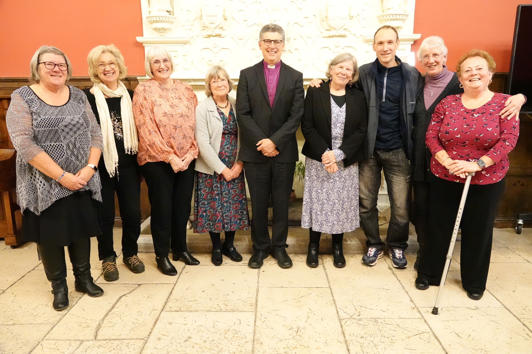 A group of people with Bishop Martin having just received their certificates