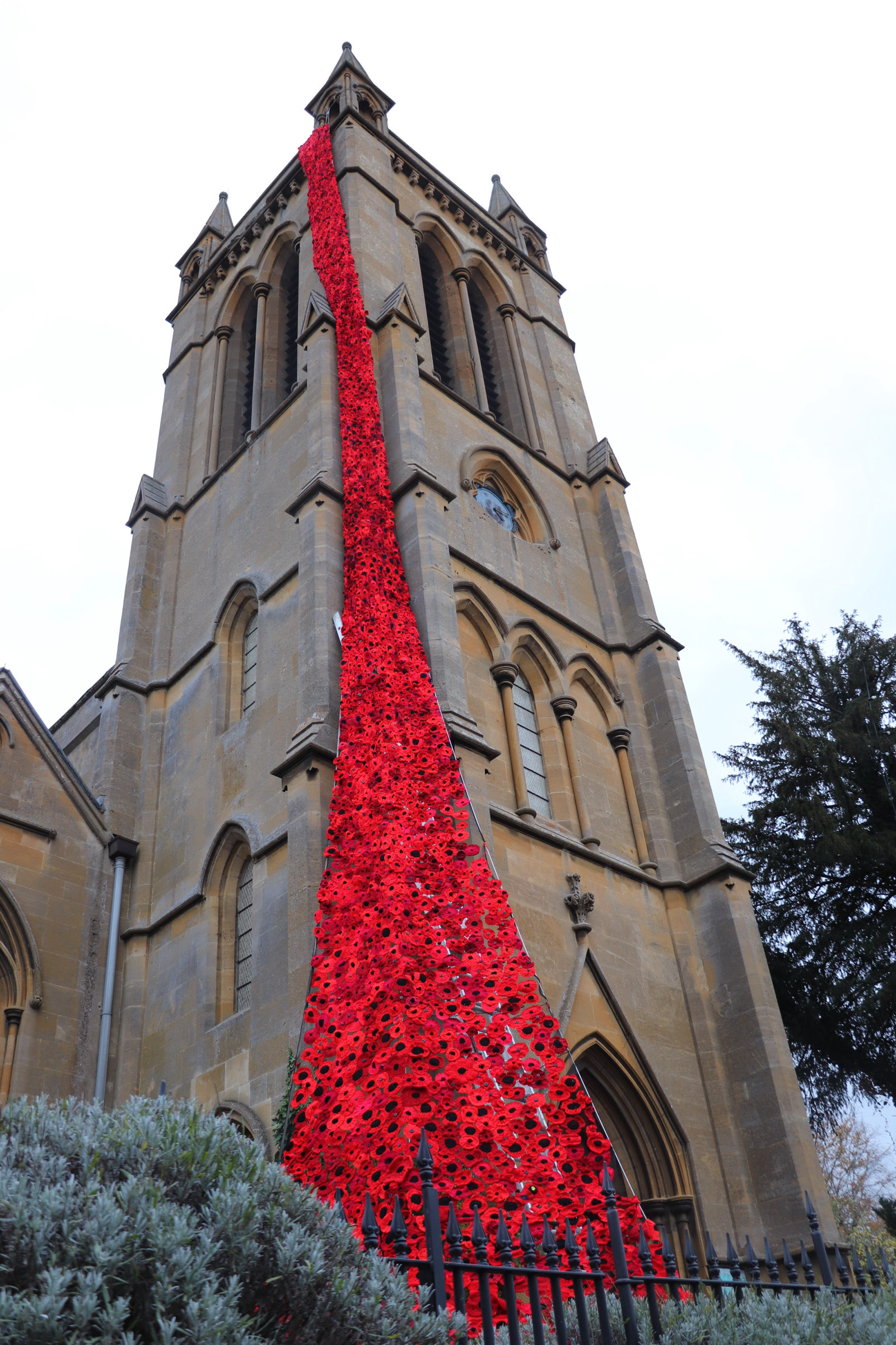 A cascade of knitted poppies stretching from the top of Broadway church tower to the ground