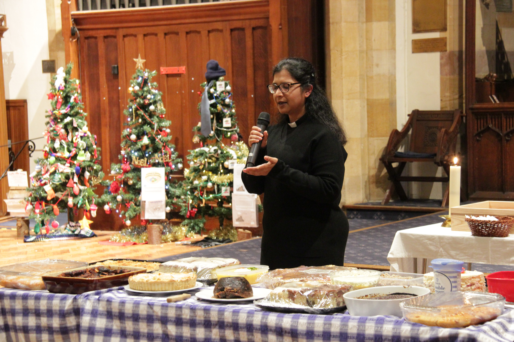 Prajna standing behind a table full of puddings as she says a prayer over them