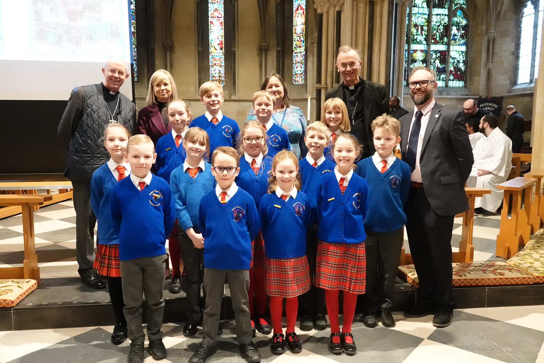 Children from Himbleton first school standing at the front of Pershore Abbey with Archbishop Justin