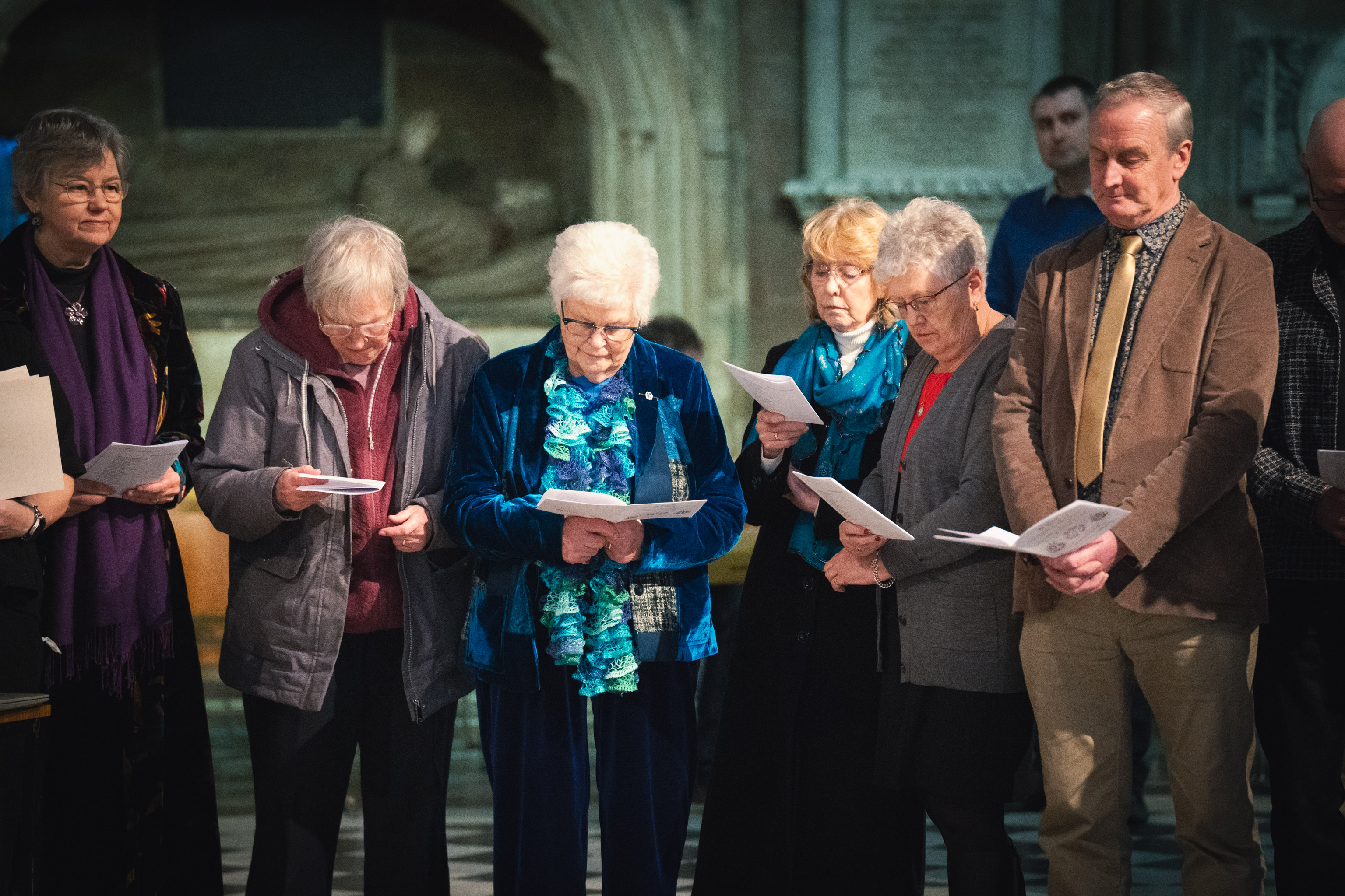 A group of people standing in the cathedral holding ALM certificates
