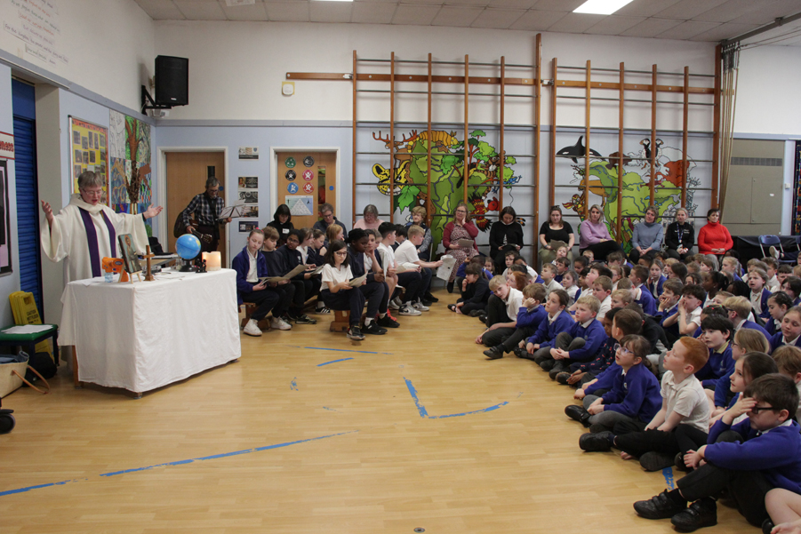 Sarah Northall presiding over the eucharist at the front of st barnabas assembly.