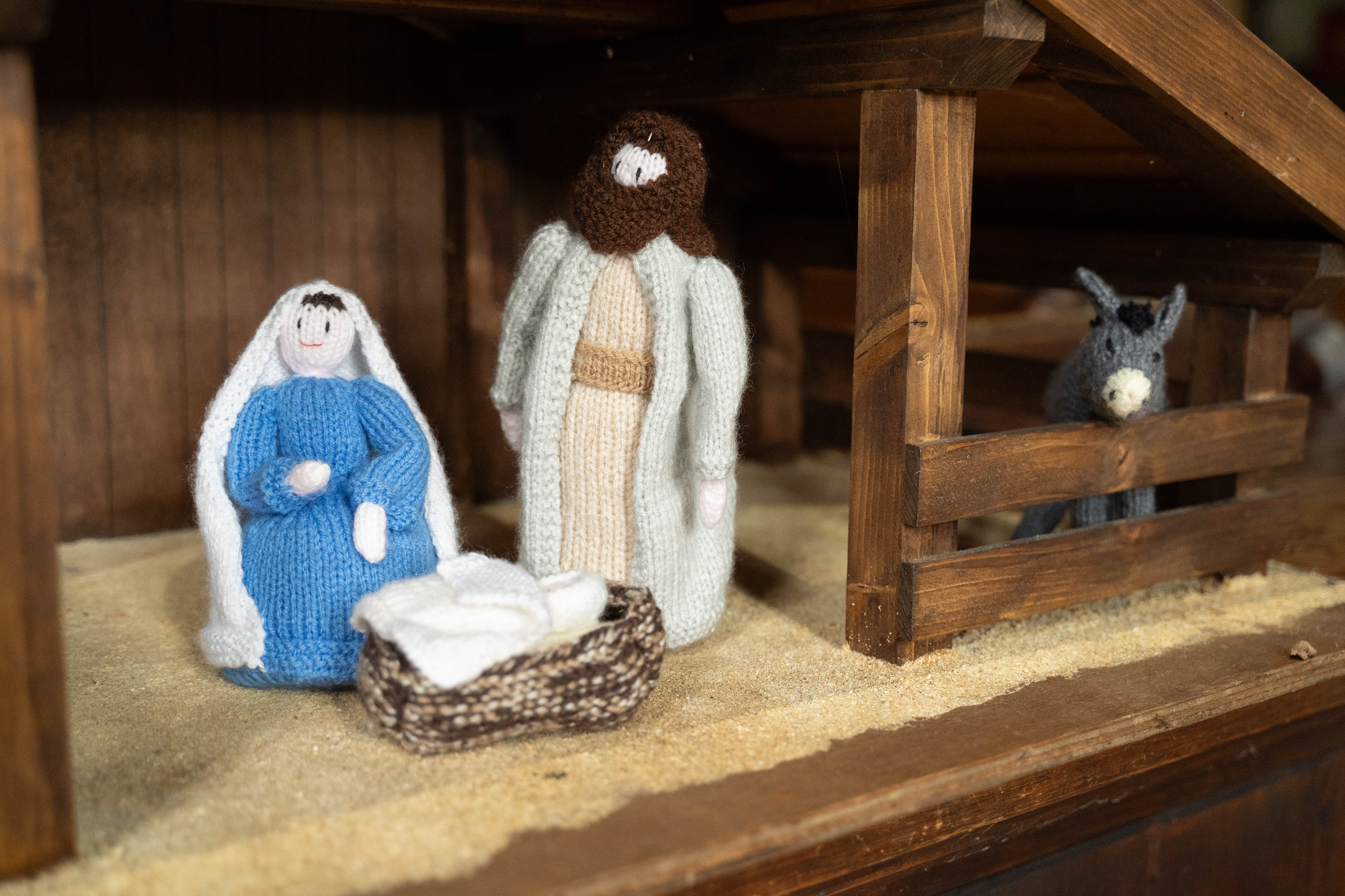 Knitted mary, joseph, baby jesus and the donkey in a stable