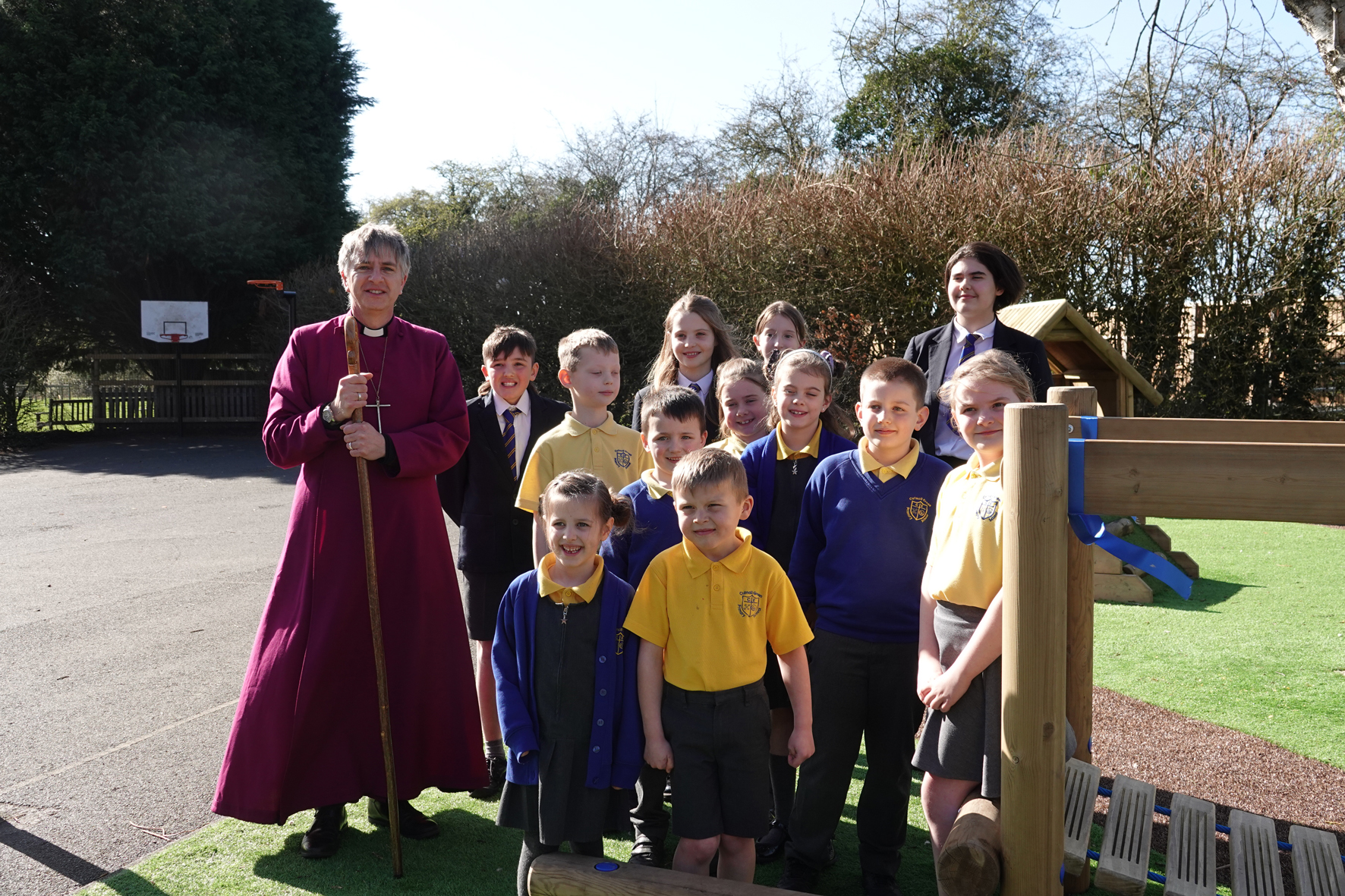 Children from Cutnall Green Primary standing with Bishop Hugh