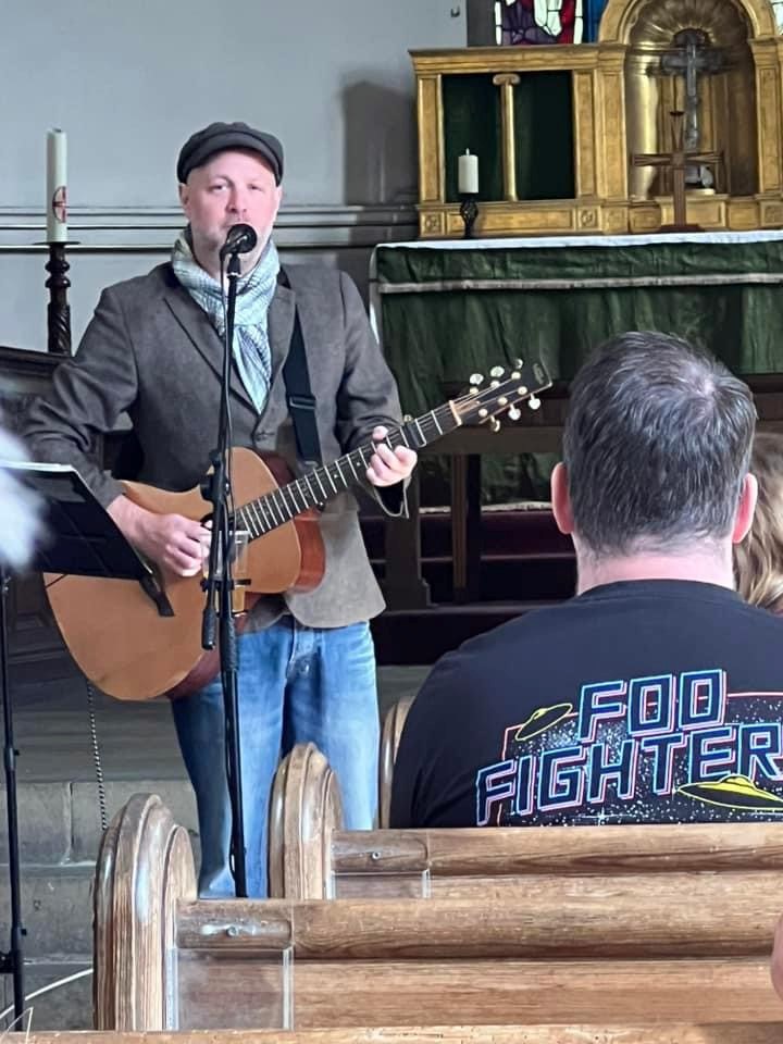 Dan Sealey playing his guitar at the front of Tardebigge church