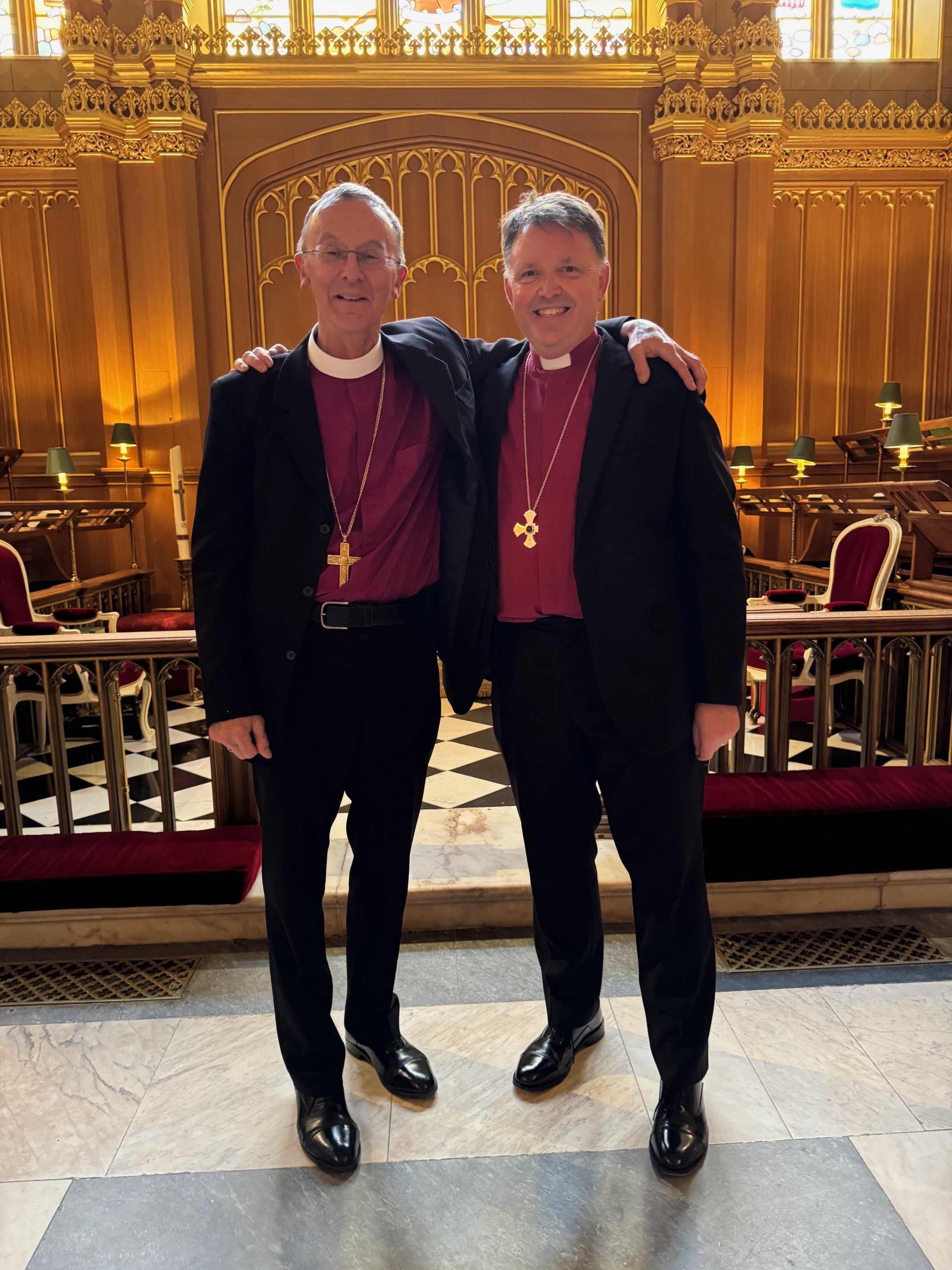 Bishop John and Bishop Martin with their arms around each other during their visit to the King