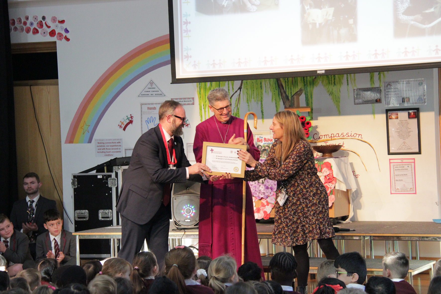 Tim Reid and Bishop Martin hand the award certificate to headteacher Mrs Snape