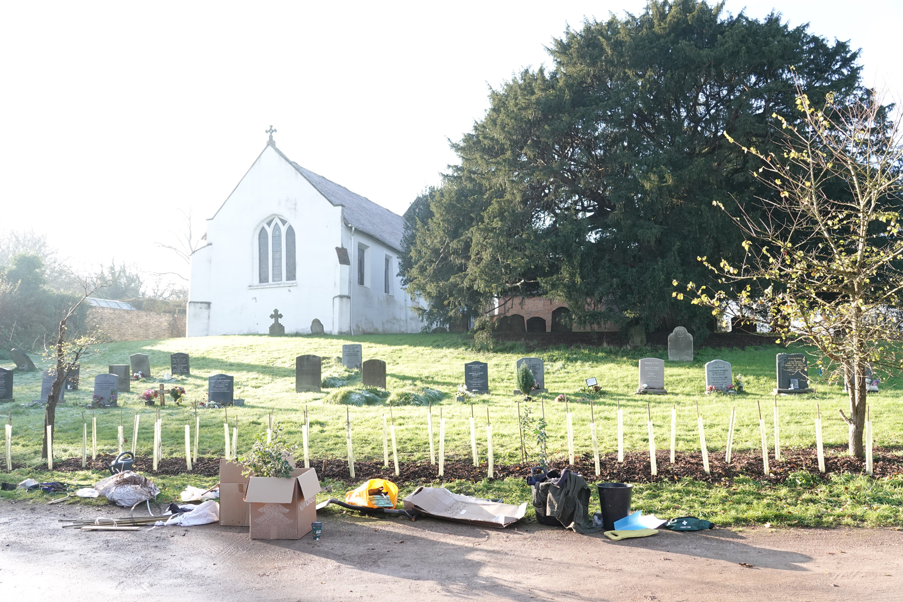 St Nicholas Church in Warndon with a new hedge being planted at the edge of the churchyard