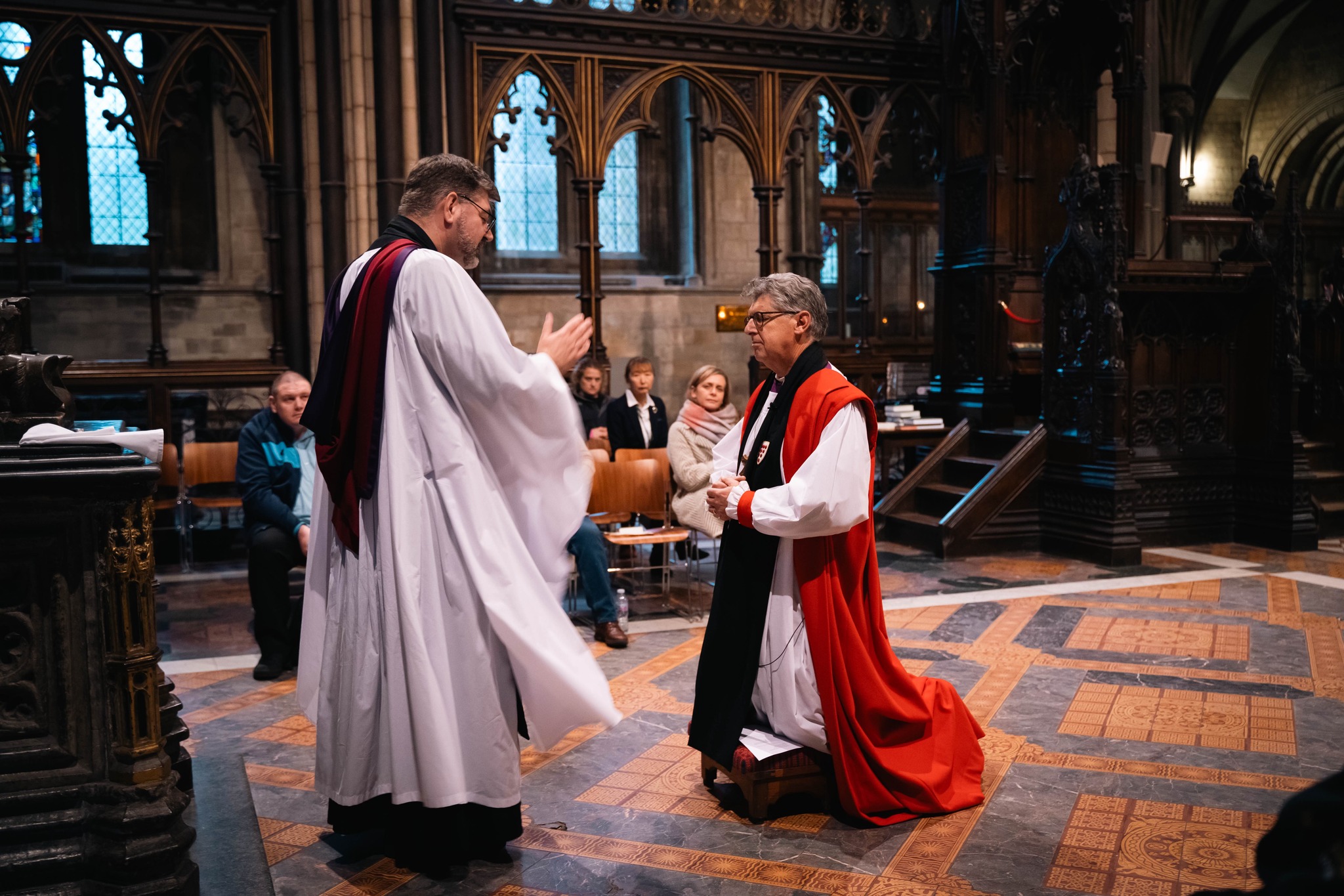 The Dean blessing Bishop Martin who kneels before him in the Quire