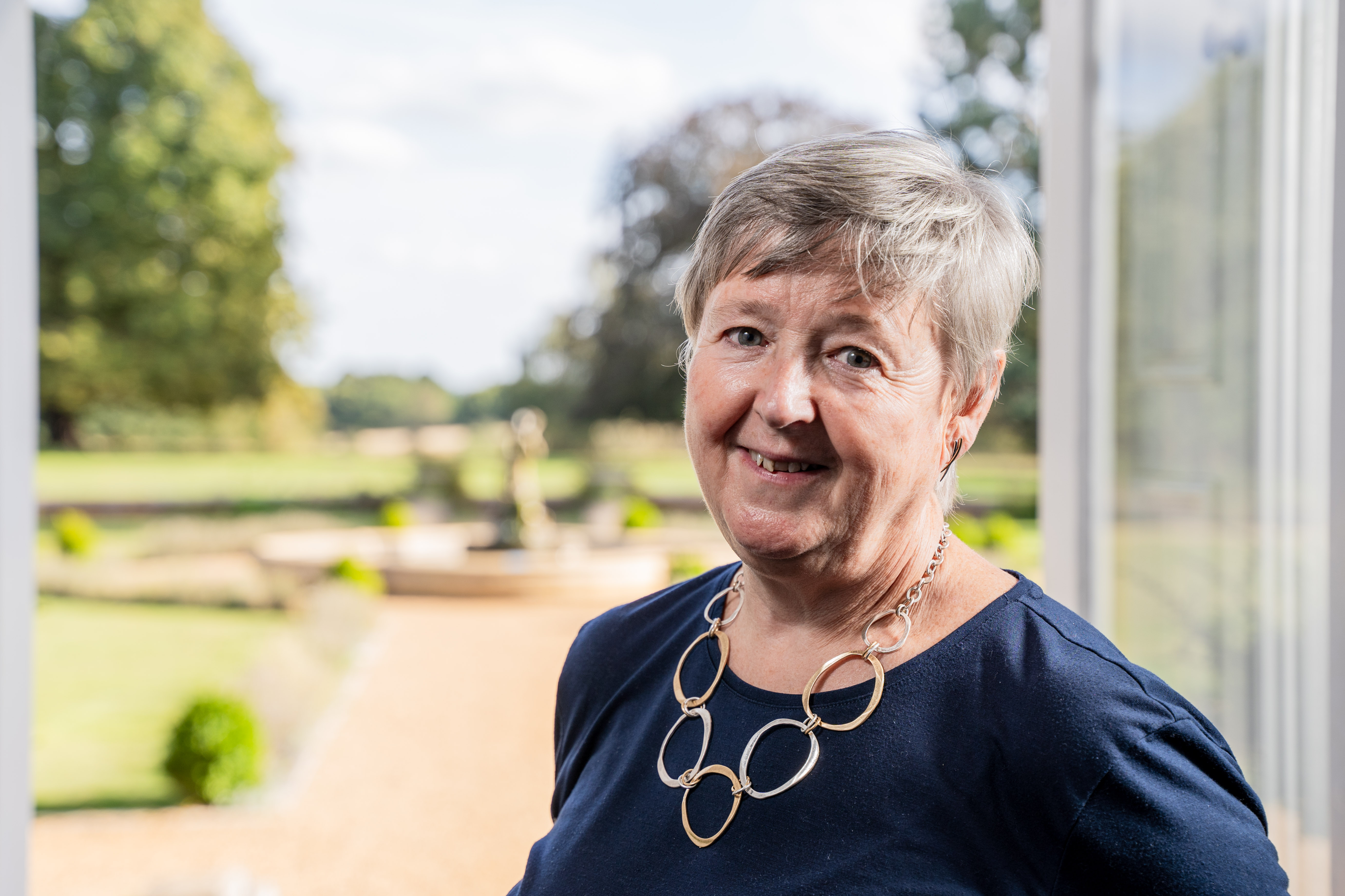 Alison Maddocks standing in front of an open doorway looking into a garden