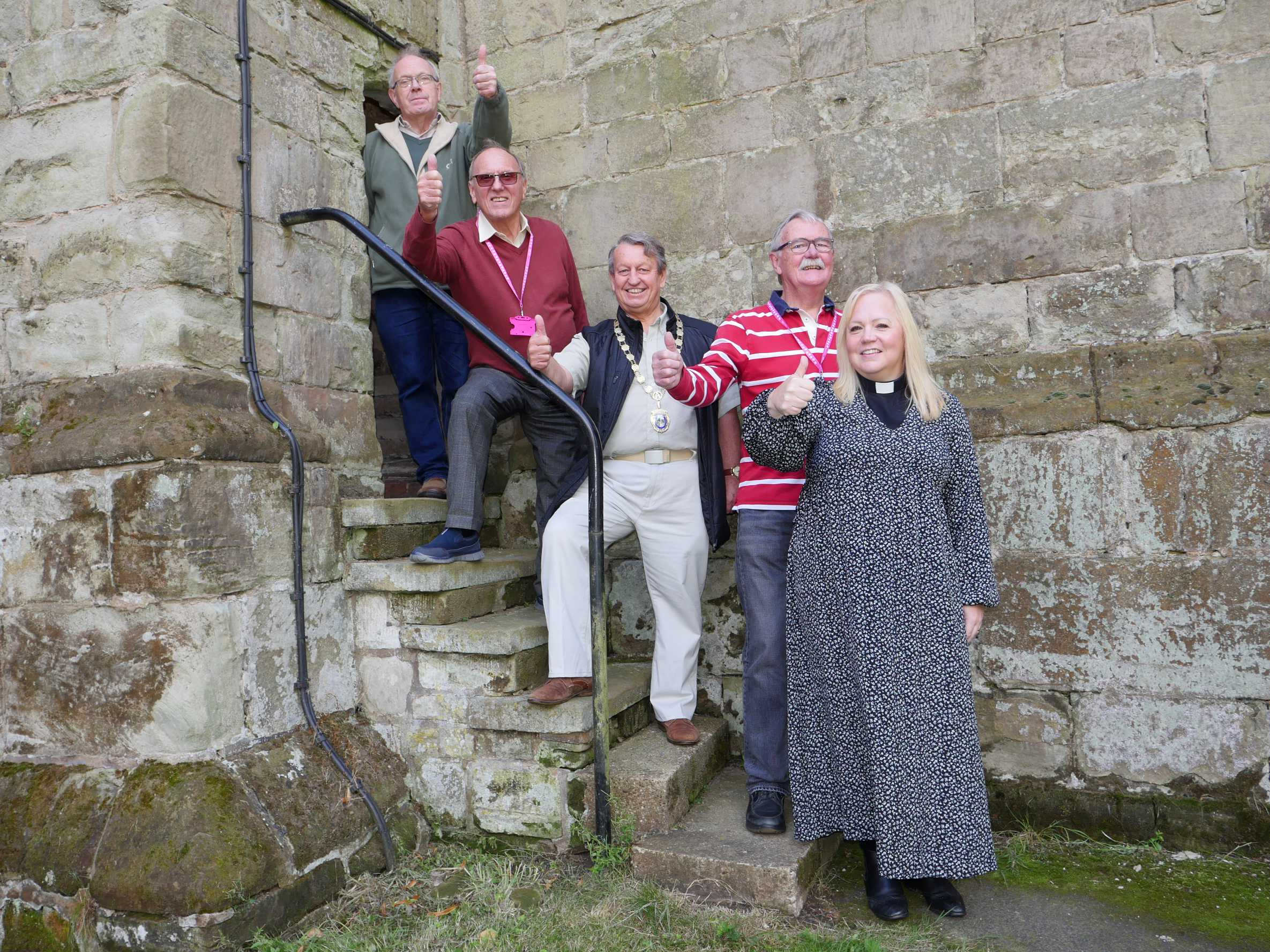 People standing on the steps at St Laurence Alvechurch with their thumbs up to say thank you for the funding