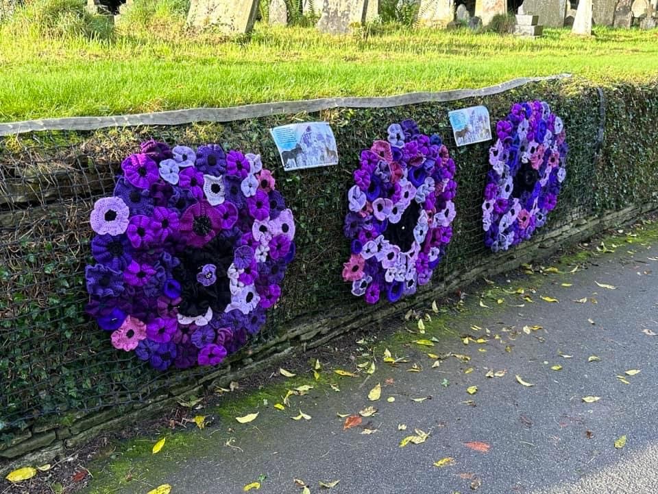 Three wreaths of purple poppies on the church wall