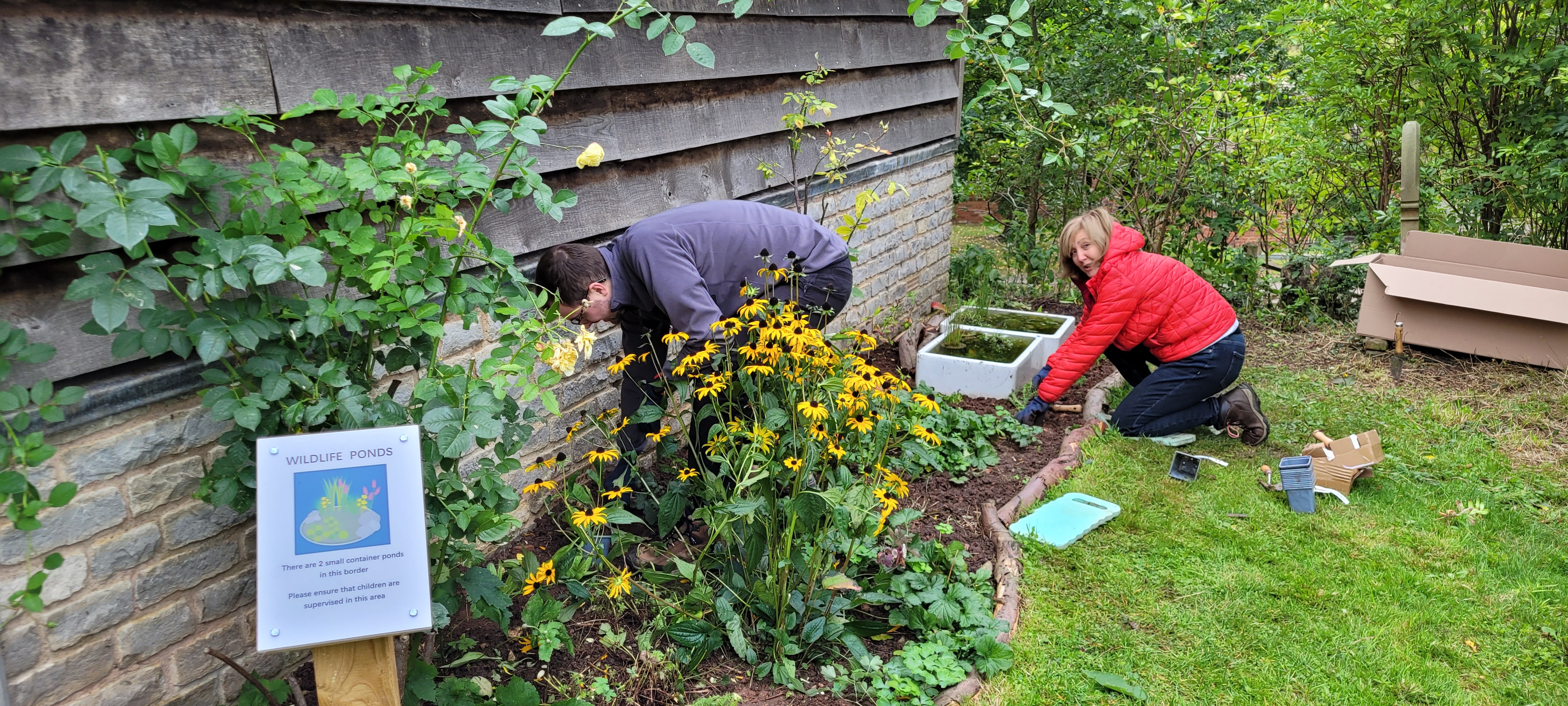 Two people working in flower beds at St Nicholas, Warndon