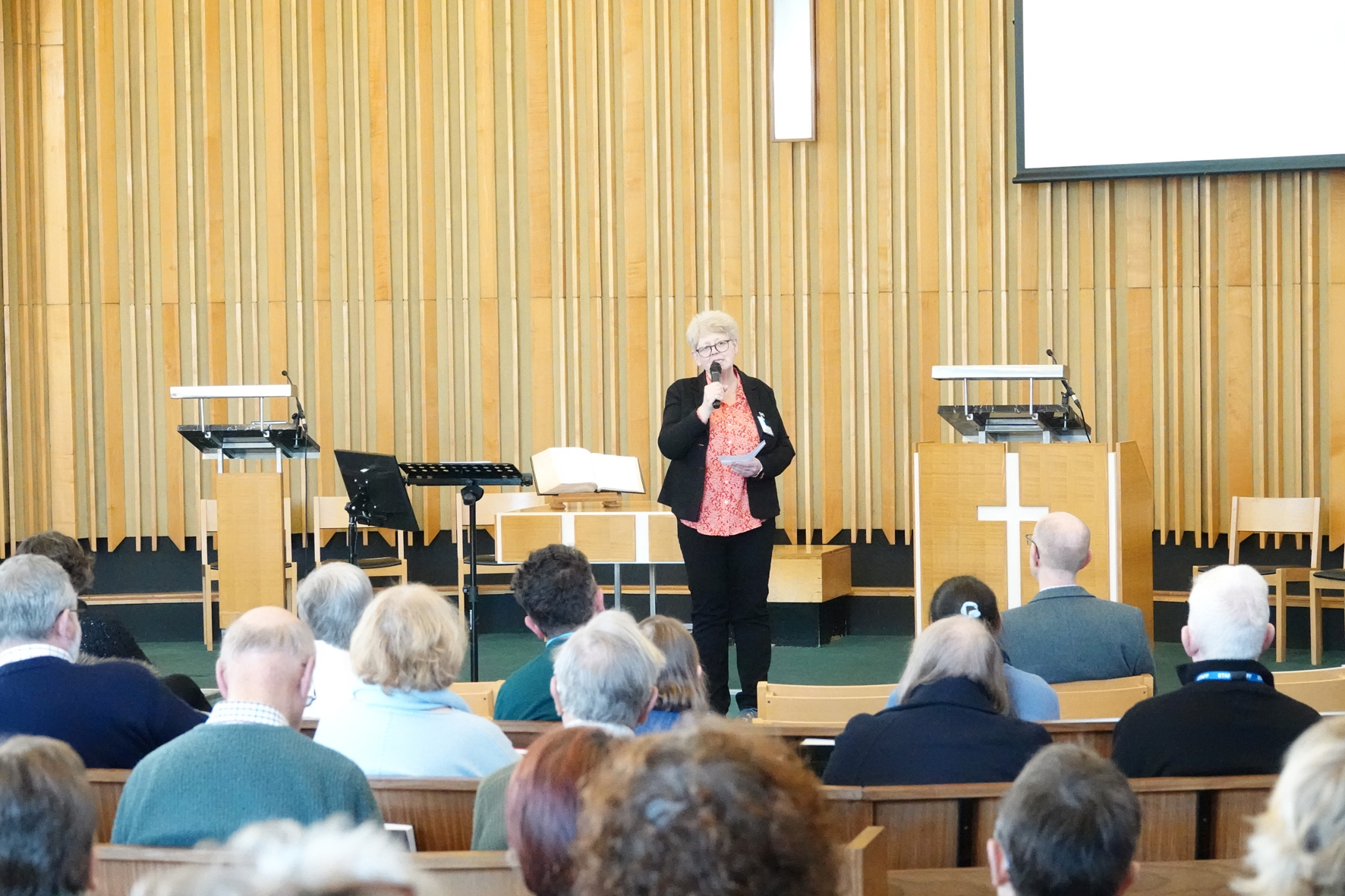 Kim Brown standing on a stage in front of a group of people