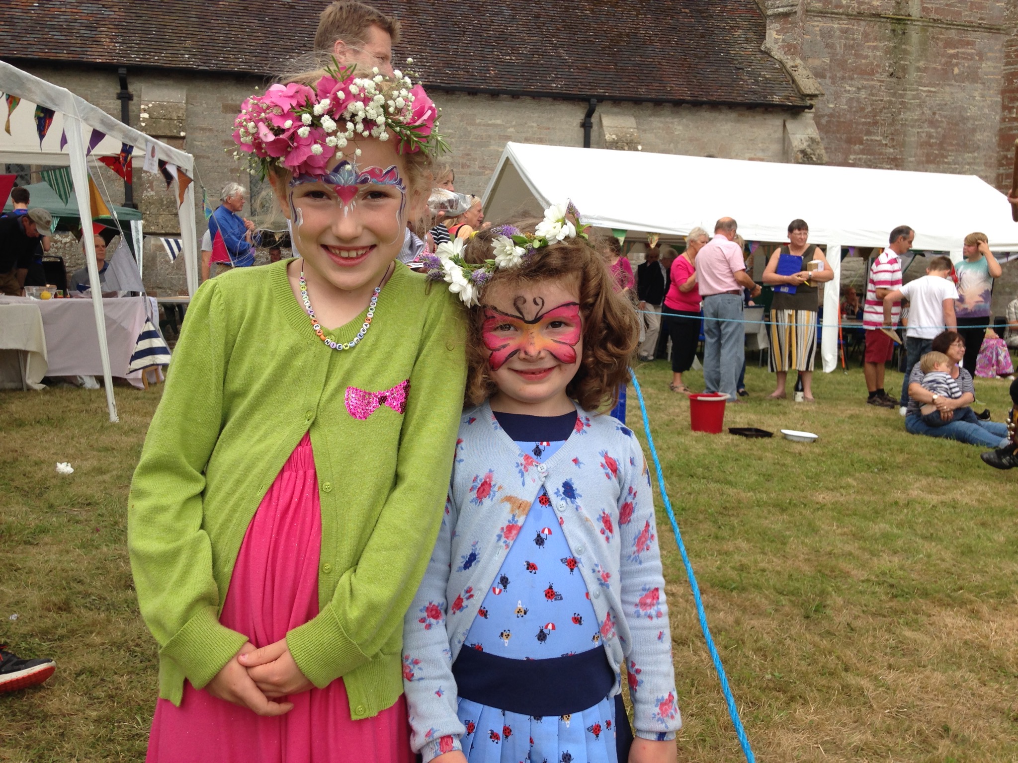 Two girls with facepaint at the summer fete outside Bishampton church