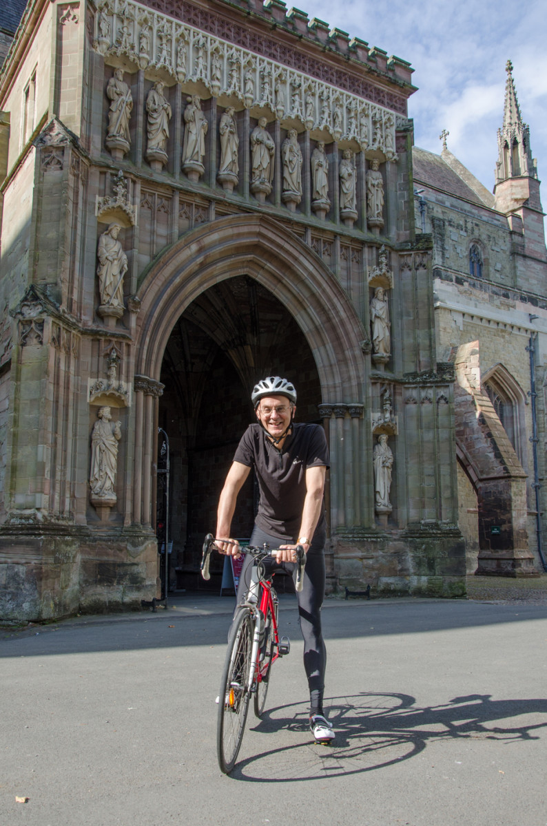 Bishop John on his bike outside the Cathedral