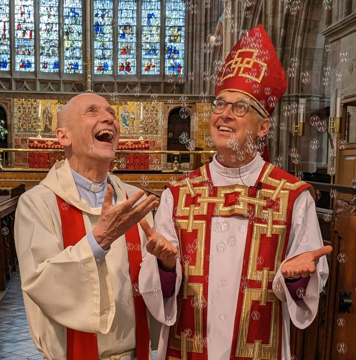 The Revd Rod Corke and Bishop Martin being showered with bubbles in the Priory.