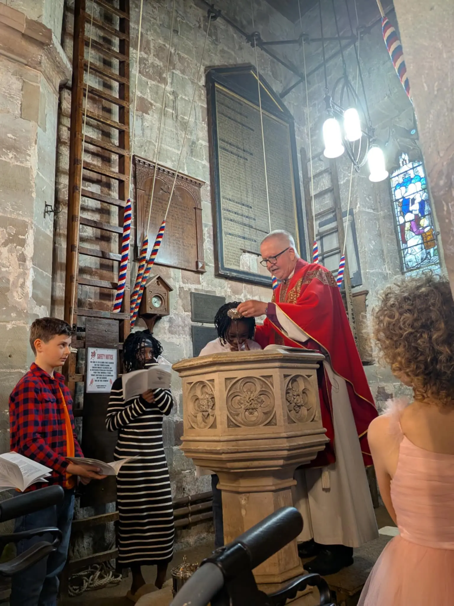 Bishop Alan baptising a candidate at the font in Claines church