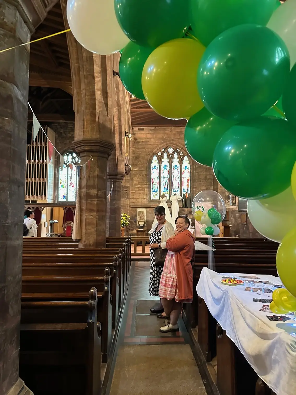 A couple of the helpers at the wedding fayre underneath a balloon arch