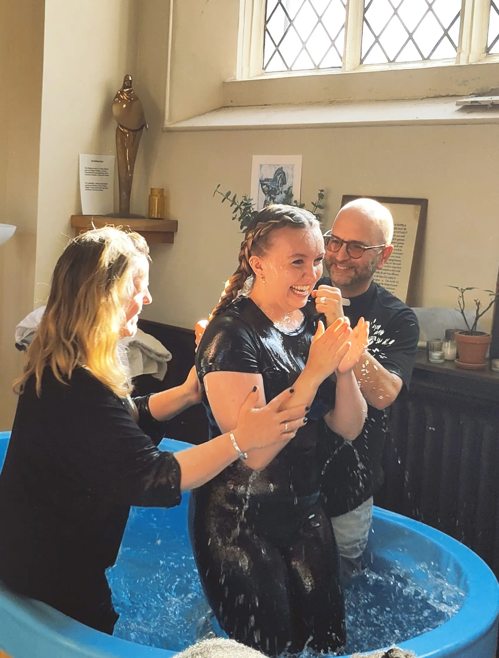 Girl laughing having just received full emersion baptism with James and Esther Treasure either side of her