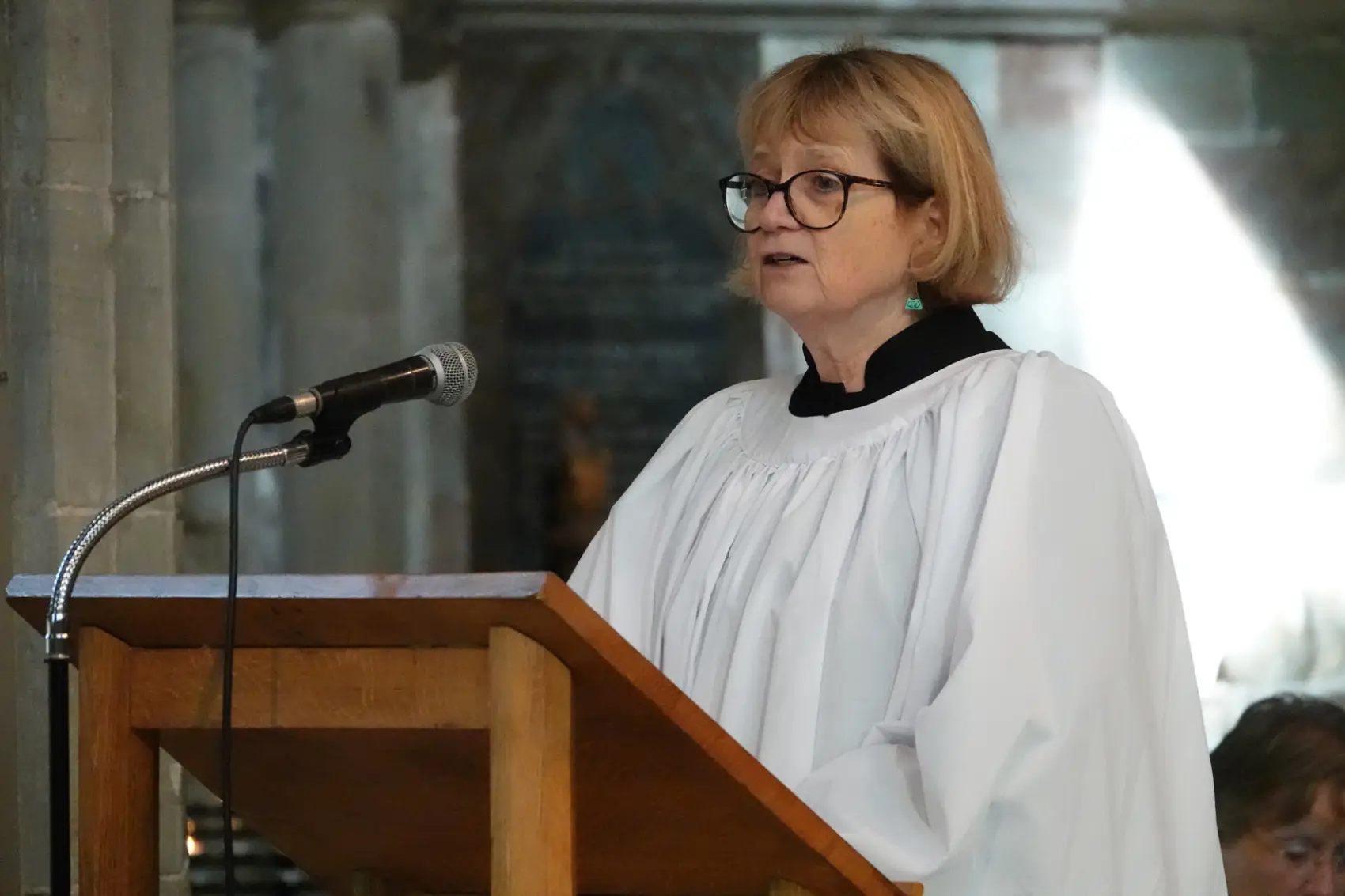 Barbara Adams standing at a lectern in the cathedral