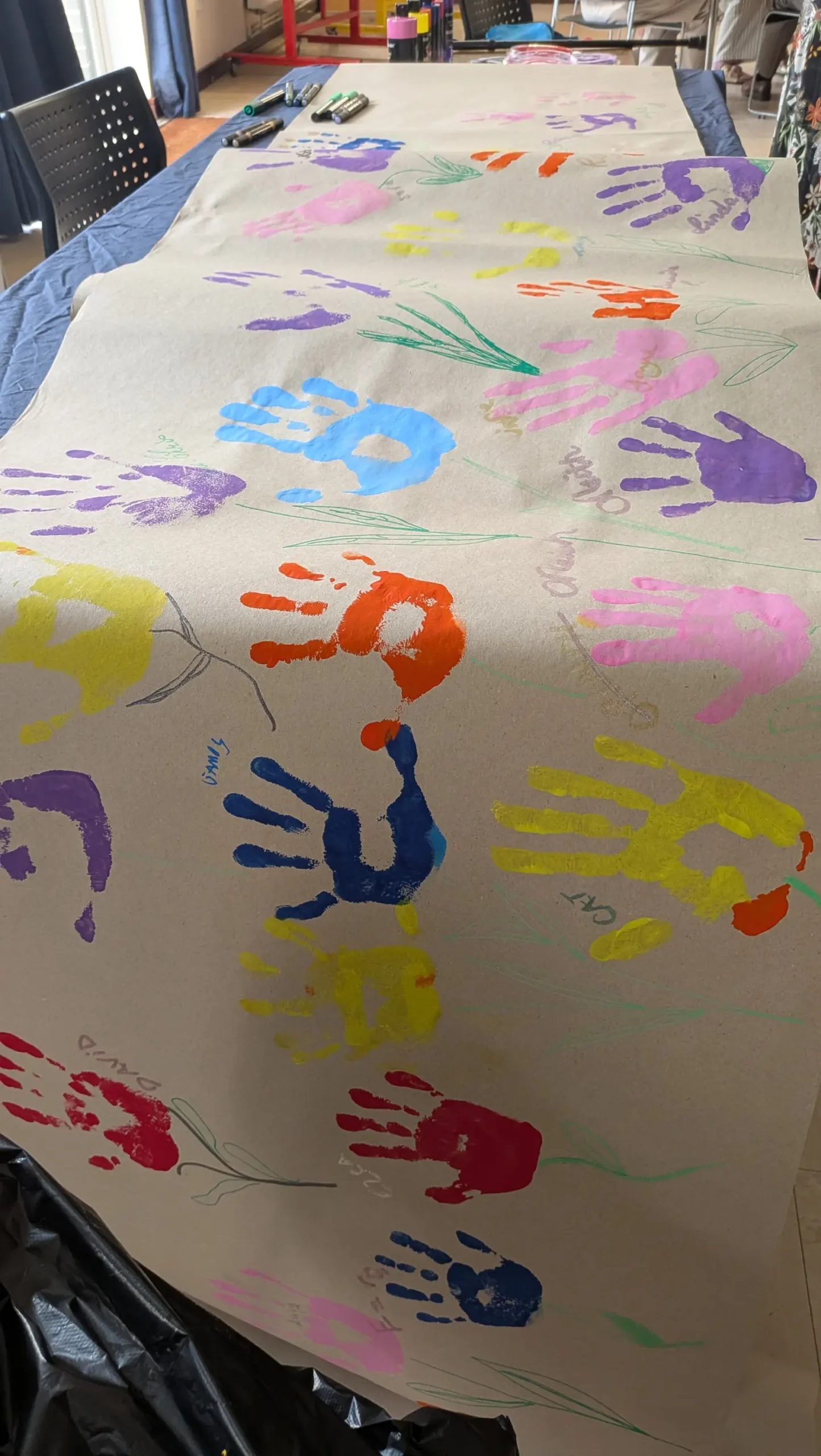 Multi colour hand prints spread over a long piece of material