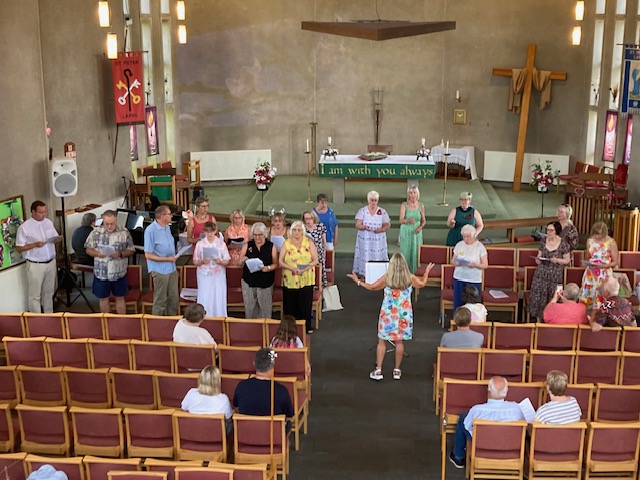 Members of Lapal community choir standing at the front of church to sing