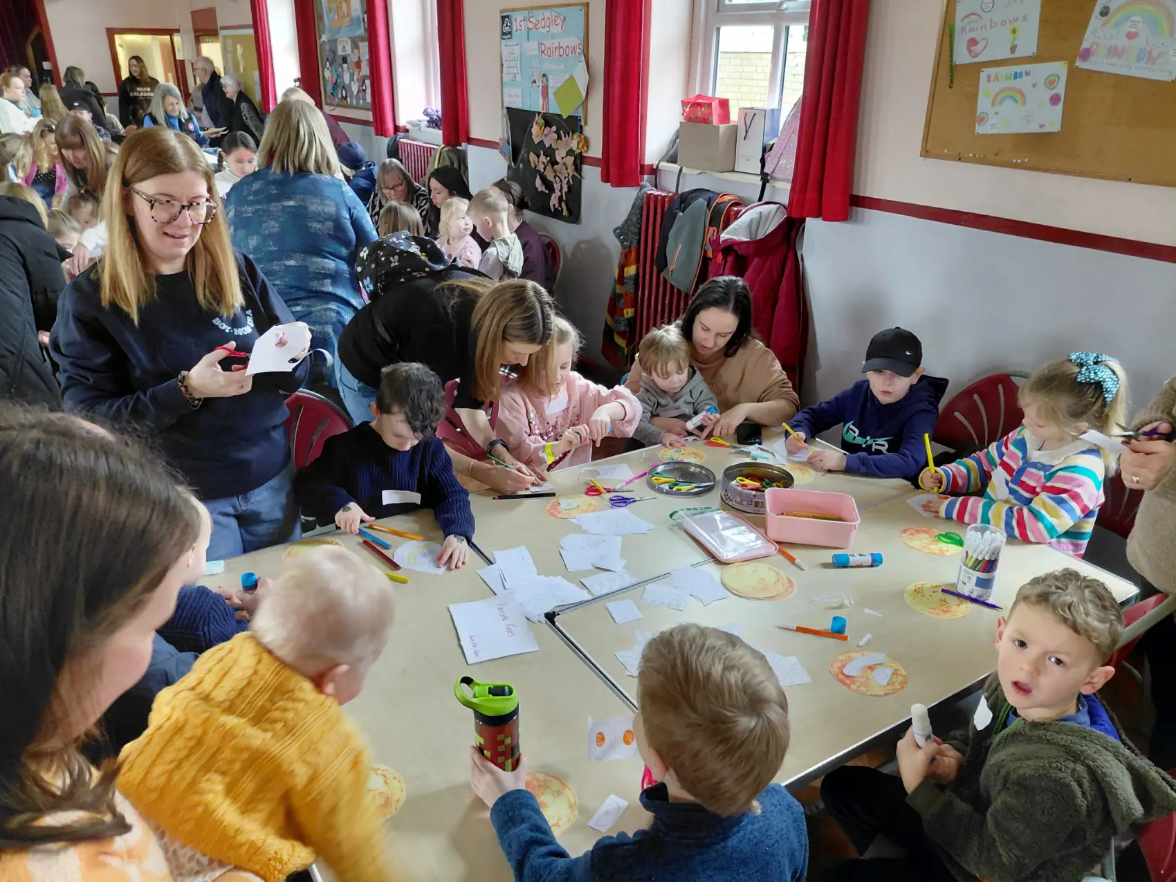 A group of people sat around a table doing craft